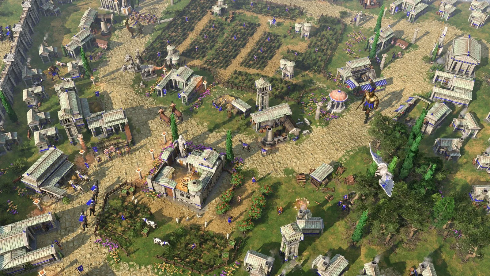 Vista aérea de una ciudad griega amurallada rodeada de campos y bosques en Age of Mythology: Retold