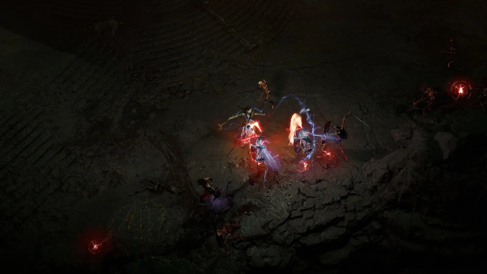 Un grupo combate con hechizos rojos en una cueva oscura en Diablo IV