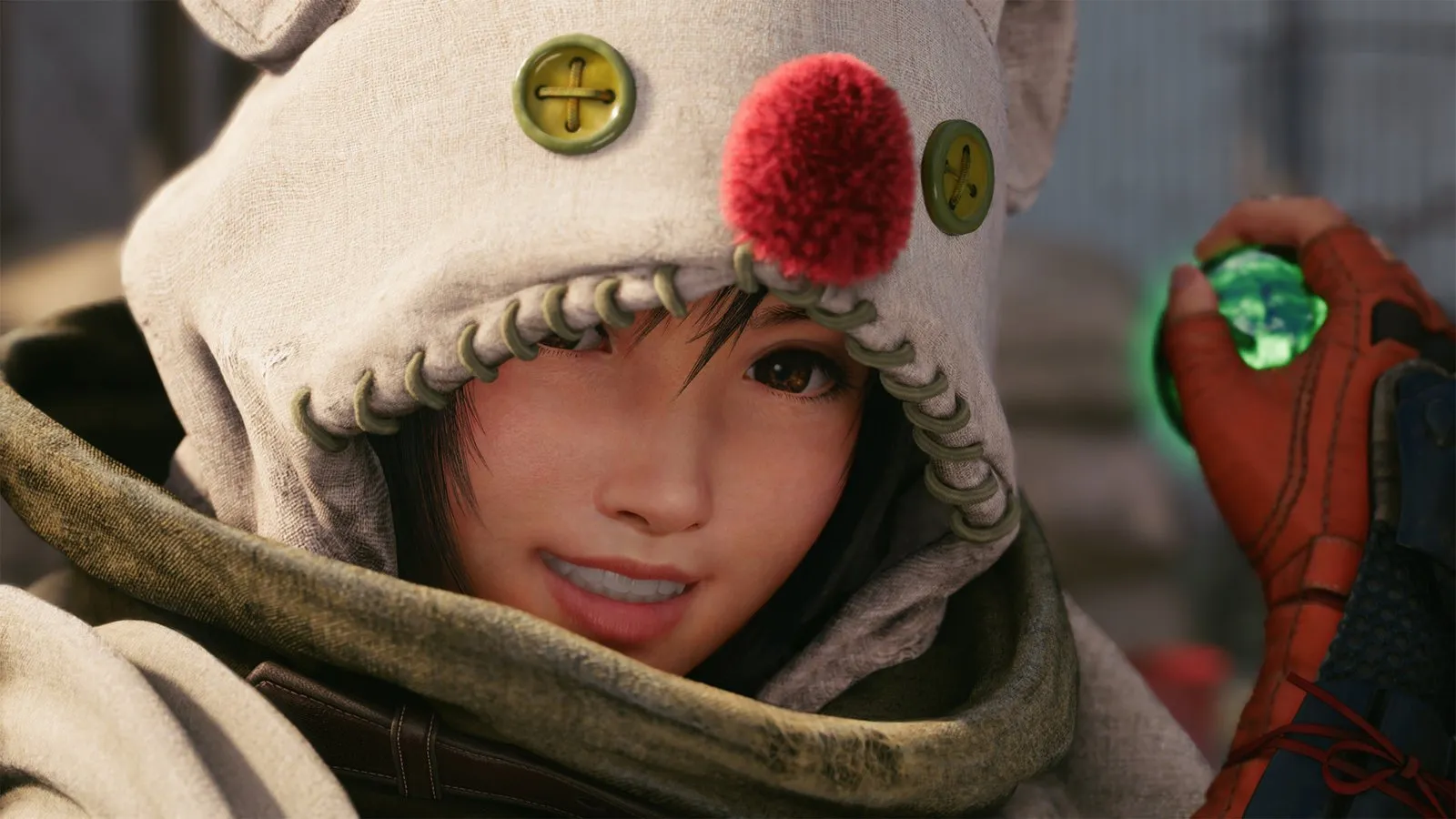 Yuffie, con capucha blanca y pompón rojo, sonríe sosteniendo una materia verde en FINAL FANTASY VII REMAKE