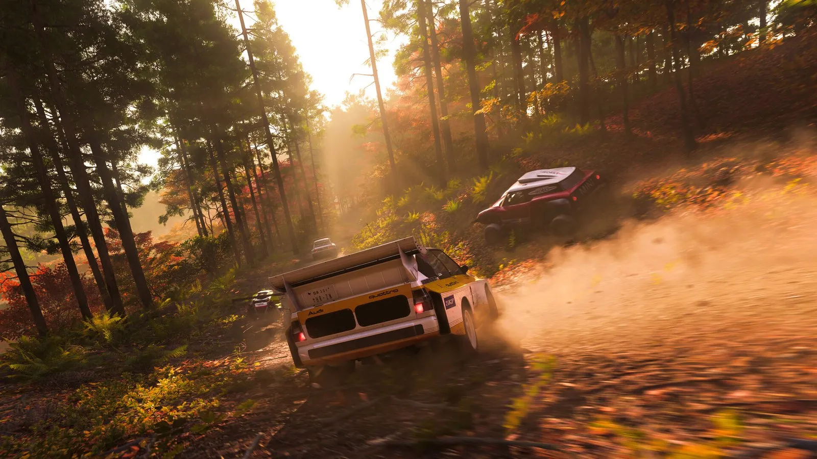 Dos coches de rally derrapan por una pista de tierra en un bosque de arces rojos en Forza Horizon 6