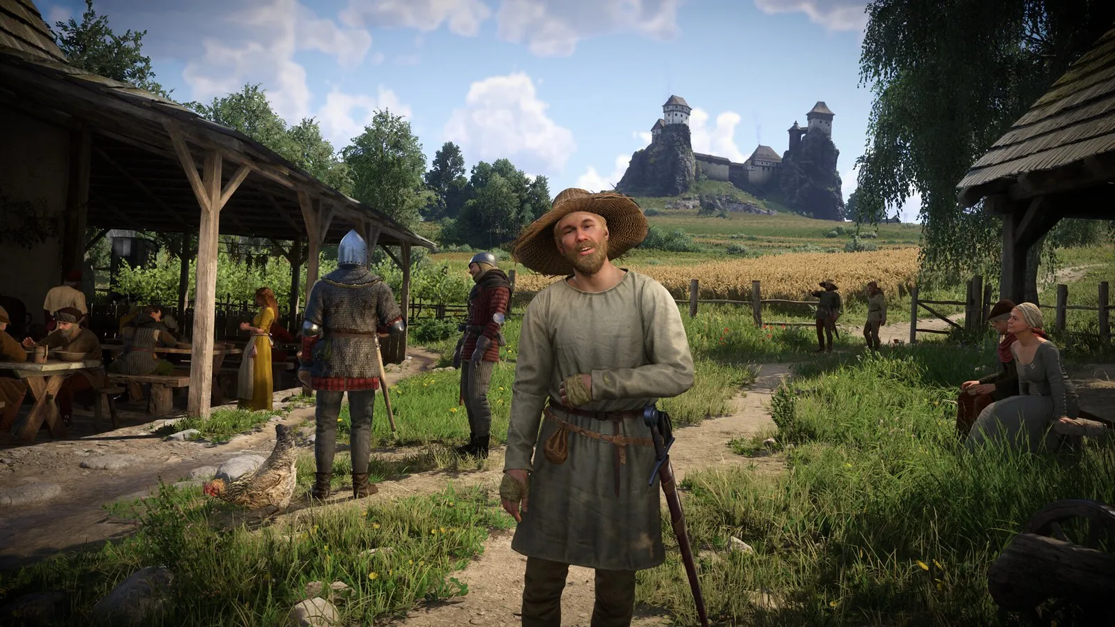 Un campesino con sombrero de paja conversa con Henry en una aldea con un castillo al fondo en Kingdom Come: Deliverance II
