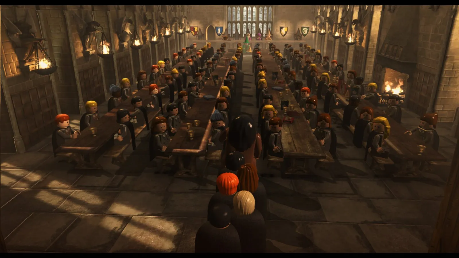 El Gran Comedor de Hogwarts lleno de alumnos LEGO sentados en las mesas de las casas en LEGO Harry Potter Collection