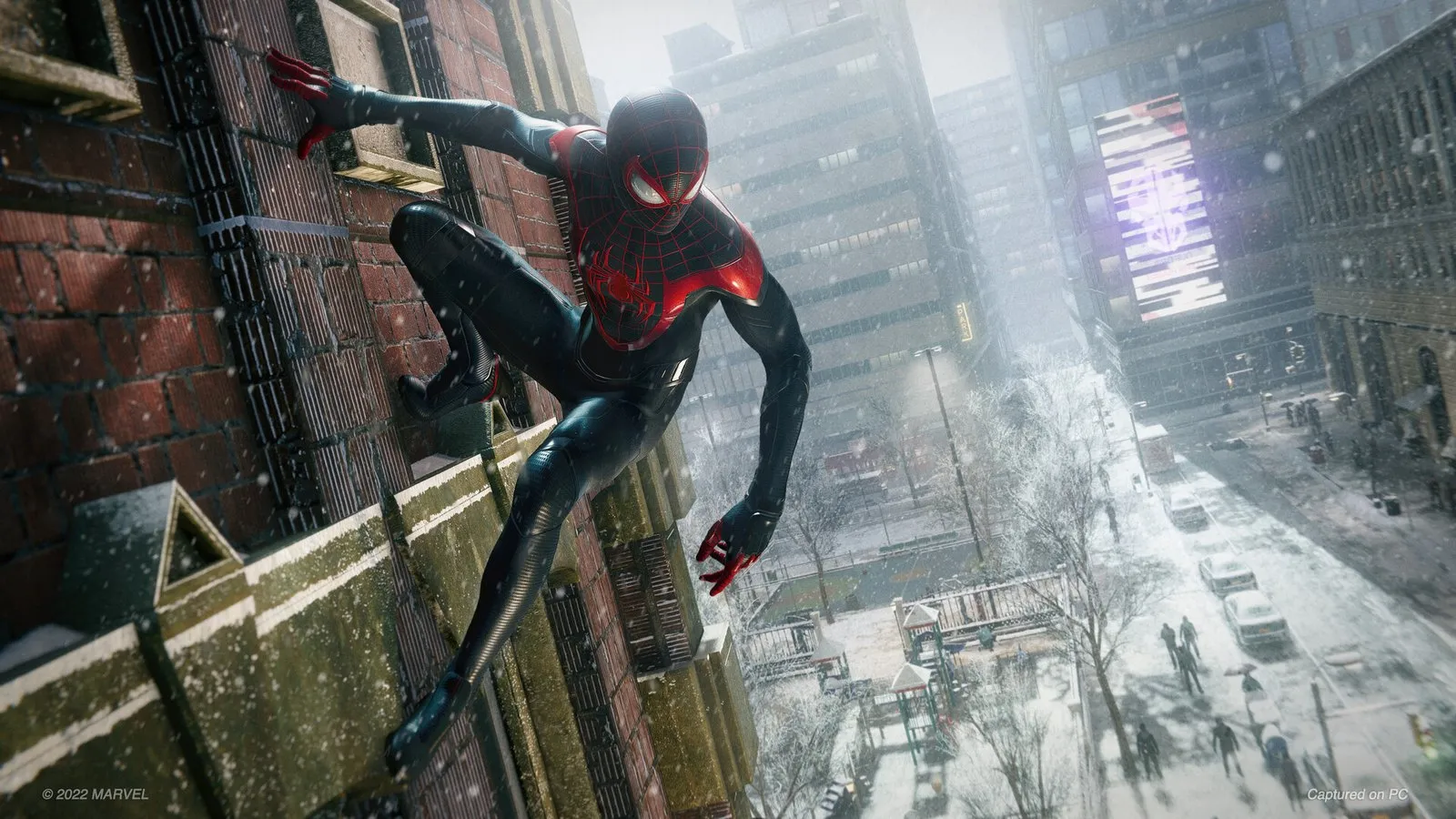 Miles trepa por una pared de ladrillo sobre una calle nevada de Nueva York en Marvel's Spider-Man: Miles Morales