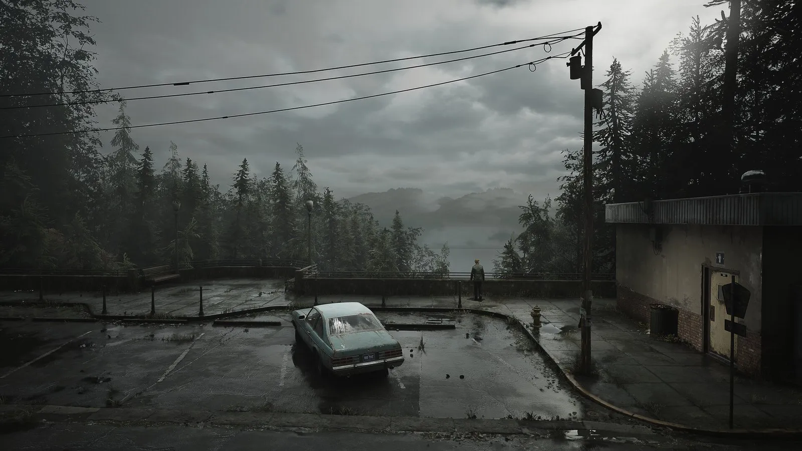 Un aparcamiento vacío con un coche abandonado bajo un cielo gris y niebla en SILENT HILL 2