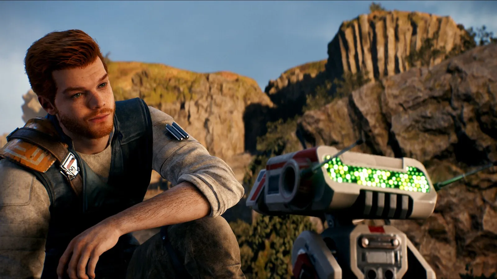 Cal Kestis, con el pelo rojo, mira de perfil junto a BD-1 en un paisaje rocoso en Star Wars Jedi: Survivor